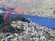 Paraglider sobrevoando a cidade de Queenstown, Nova Zelândia